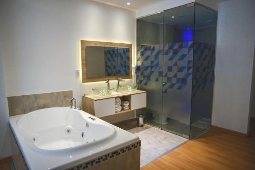 łazienka z dużą wanną i prysznicem w obiekcie Santa Cecilia Resort & Spa I w mieście Villa Carlos Paz
