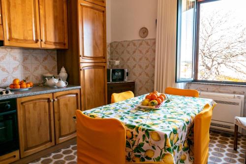 uma cozinha com uma mesa com uma taça de fruta em le Rose di santina em Mamoiada