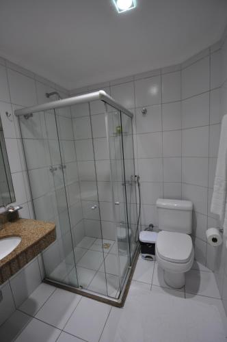 een badkamer met een douche, een toilet en een wastafel bij Barravento Praia Hotel in Ilhéus