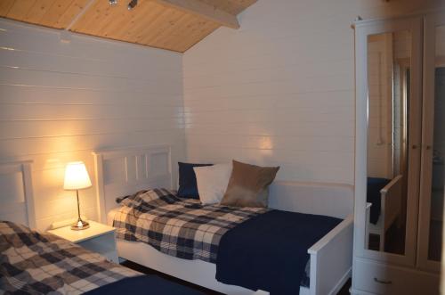 a bedroom with two beds and a lamp on a table at Chalet t Kla-viertje in Klarenbeek