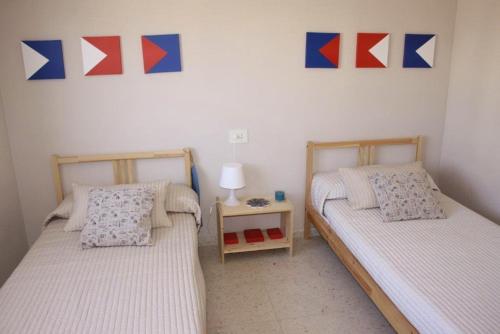 2 aparte bedden in een kamer met een lamp en een tafel bij Fuengirola Playa y céntrico in Fuengirola