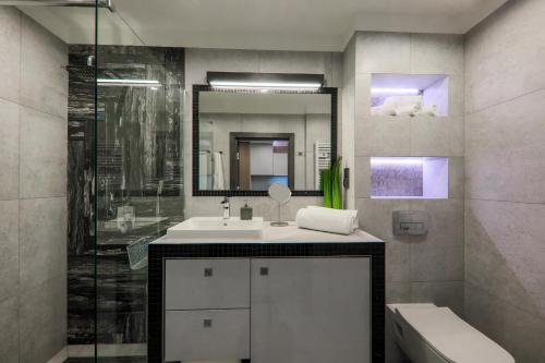 a bathroom with a sink and a shower and a mirror at Apartament Marron in Szczyrk