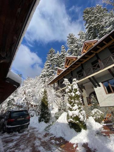 a car parked in front of a house covered in snow at Вілла Лісова комфорт in Skhidnitsa
