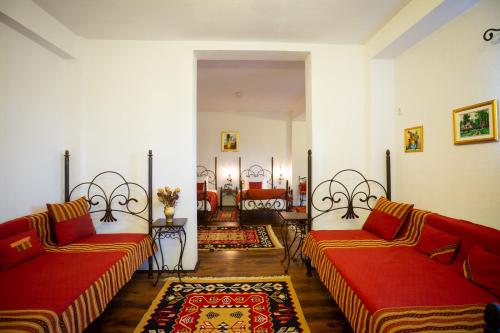 una sala de estar con 2 sofás rojos y una alfombra en Complex Turistic "Moara Dragaicilor" en Buzau