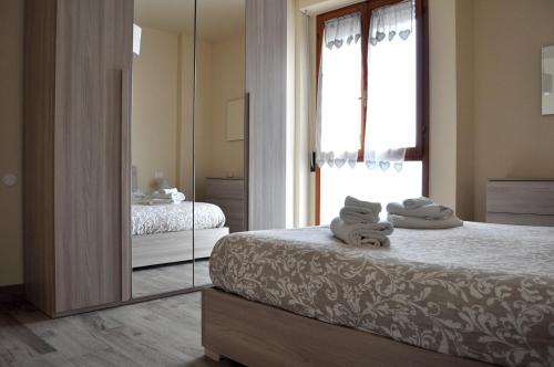 A casa di Lisa in Cisanello في بيزا: غرفة نوم مع مرآة وسرير مع المناشف