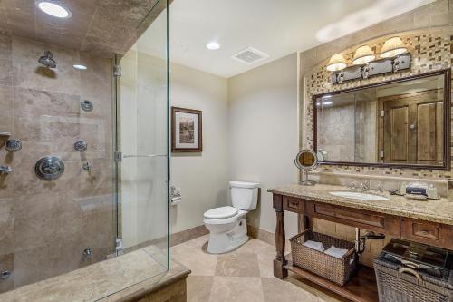 a bathroom with a shower and a toilet and a sink at The Aspen Mountain Residences in Aspen