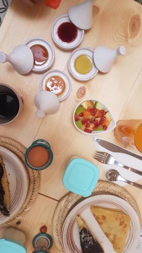 Una mesa de madera con platos de comida encima. en RIAD Miel & Une Nuit, en Marrakech