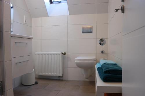 a white bathroom with a toilet and a sink at Rentaroom-Kassel in Kassel