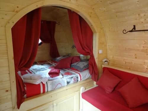 een slaapkamer met 2 bedden in een hut met rode gordijnen bij LES GITES DU PARC MANTOCHE LE TONNEAU in Mantoche