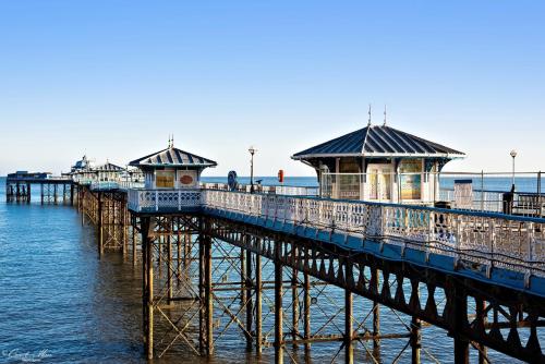 a pier with buildings on it in the water at Elsinore Hotel Llandudno in Llandudno