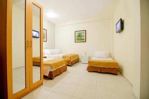 a room with two beds and a mirror at El Dorado Express Hotel in Iquitos