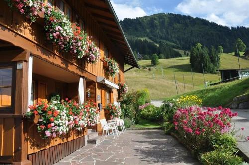 a building with flowers on the side of it at Das Bergfried - Urlaub zentral und ruhig! in Riezlern