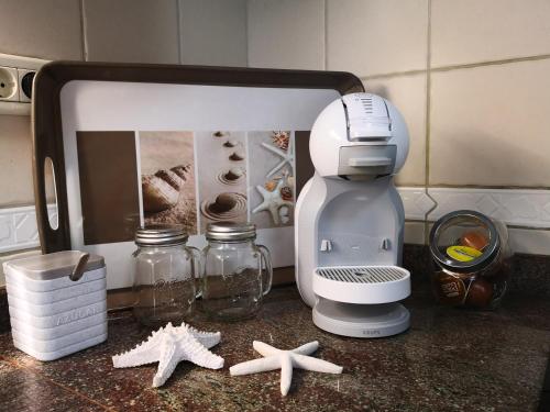 una encimera de cocina con una batidora y estrella de mar. en Apartment on the sea, en Puerto de la Madera
