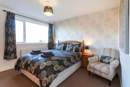 a bedroom with a bed and a chair and a window at Cedar Place in Southwell in Southwell
