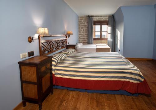 a bedroom with a bed with a striped comforter at Palacio de Pujadas by MIJ in Viana
