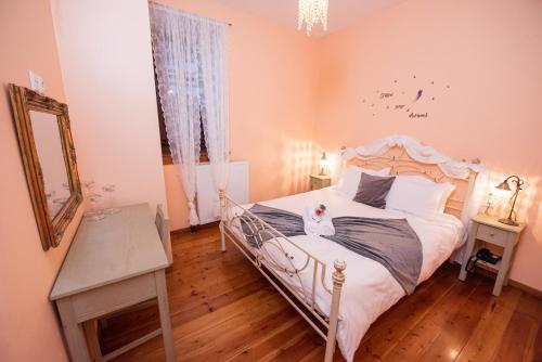 a bedroom with a bed with a cat sitting on it at Archontiko Argyro in Makrinítsa