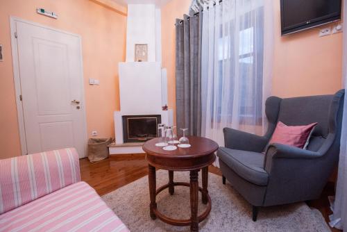 a living room with two chairs and a table at Archontiko Argyro in Makrinítsa