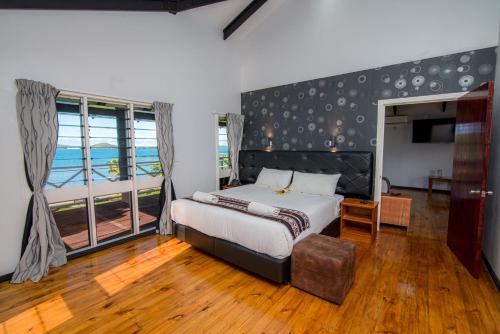 a bedroom with a bed and a large window at Dua Dua Beach Resort in Rakiraki