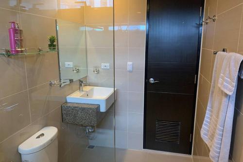 a bathroom with a toilet and a sink and a shower at One Eastwood Avenue Tower 2 in Manila