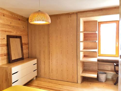 a bedroom with wooden walls and a window and a light fixture at The Place in Ponta Delgada