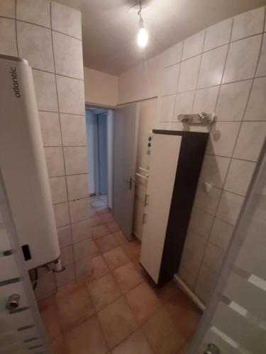 La salle de bains est pourvue d'une douche et d'une porte blanche. dans l'établissement MAISON 100 M2, Terrasse 25 m2, Clim, 3 chbs avec tv, parking, à Pierrelatte