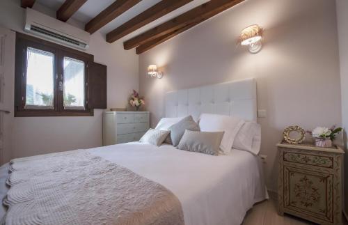 a bedroom with a large white bed and a window at La Casa del Tránsito - Living Toledo in Toledo