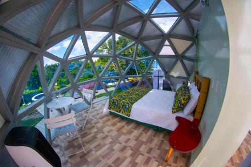 a bedroom in a dome shaped room with a large window at Eco Domo glamping in Armenia