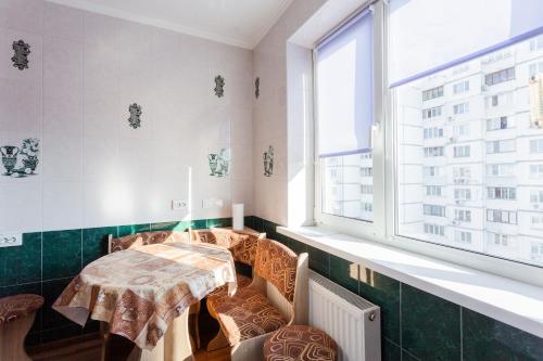 a room with a table and chairs and a window at Квартира біля ТРЦ "DREAM TOWN 2" in Kyiv