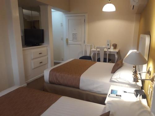 a hotel room with two beds and a television at Country Plaza in Guadalajara