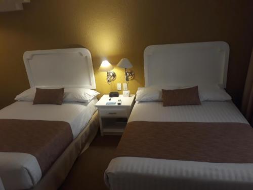two beds sitting next to each other in a room at Country Plaza in Guadalajara