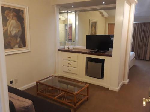 a living room with a tv and a mirror at Country Plaza in Guadalajara