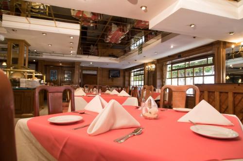 a dining room with red tables with napkins at Country Plaza in Guadalajara