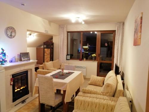 a living room with a table and chairs and a fireplace at Apartment Viki Pamporovo in Pamporovo