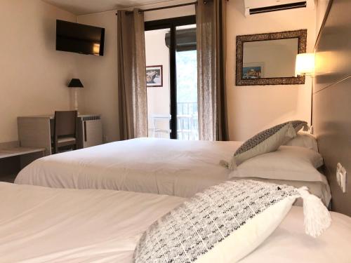 sypialnia z 2 łóżkami i lustrem w obiekcie Hotel et Résidence Cala di sole w mieście Porto Ota