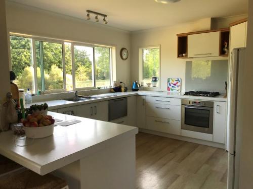 a kitchen with white cabinets and a counter top at Fieldays Dream in Tamahere