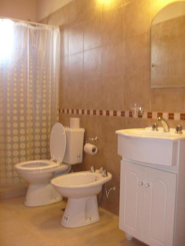 a bathroom with a toilet and a sink at Complejo Antares in San José