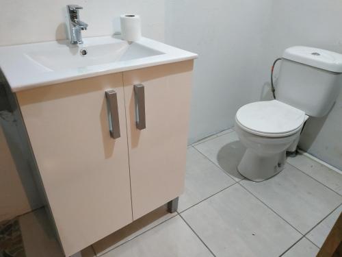 a bathroom with a white sink and a toilet at Meryem in La Trinité