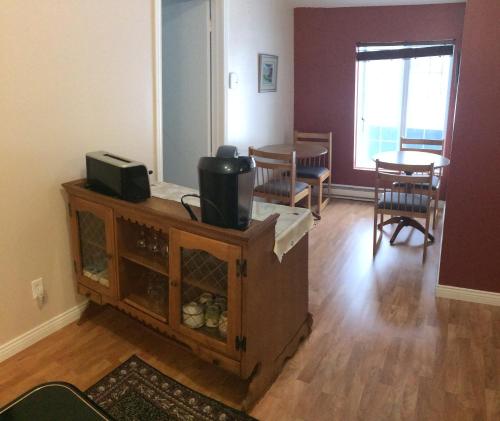 a living room with a tv and a table and chairs at Gite Duchenier in Saint-Narcisse-de-Rimouski
