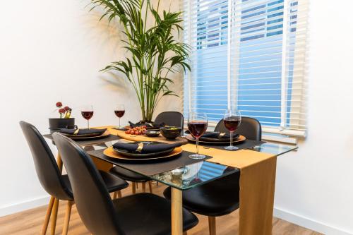 a dining room table with black chairs and wine glasses at New Pearl of Scheveningen Black Swan beach a Family loft The Hague 180A in Scheveningen