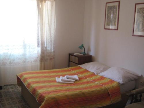 a bedroom with a bed with towels on it at Apartment Katija - close to the sea in Žirje