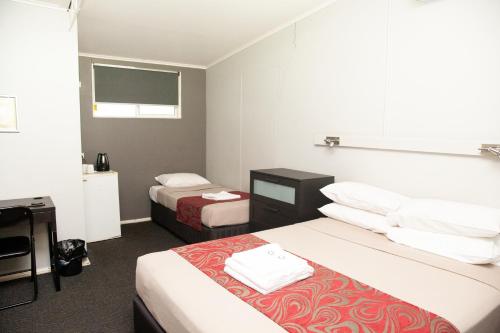 Royal Hotel Singleton tesisinde bir odada yatak veya yataklar