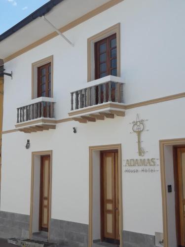 un edificio blanco con 2 balcones en el lateral en Adamas House Hotel Boutique, en Quito