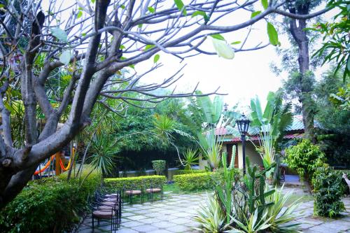 a garden with chairs and trees and plants at Anandvan Holiday Homes, Wai in Wai
