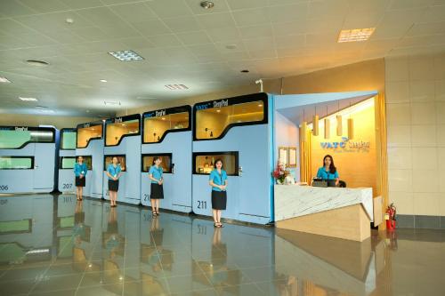 a group of people standing in a lobby at VATC Sleep Pod Terminal 1 in Noi Bai