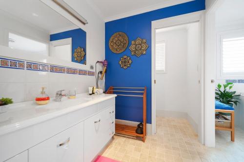 baño con paredes azules y lavabo blanco en Marche Home Stay, Immaculate Presentation, Private & Relaxing, en Lambton