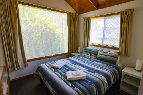 a bedroom with a bed with towels on it at Beauty Point Tourist Park in Beauty Point