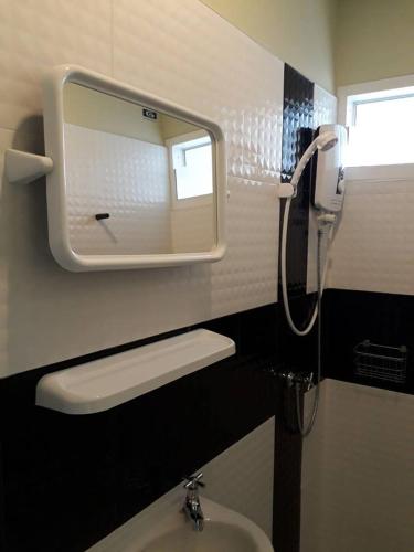 a bathroom with a sink and a mirror on the wall at Kim Casa in Nakhon Sawan