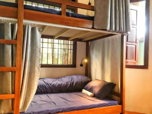 a bedroom with two bunk beds and a window at Chino Homestay Măng Đen - Villa tại Măng Đen in Kon Tum