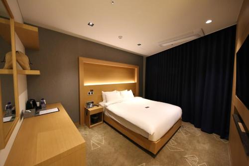 a bedroom with a white bed and a black wall at Sea Cruise Hotel in Sokcho