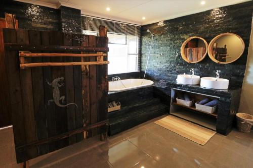 a bathroom with two sinks and a bath tub at Ngalali Retreat in Grietjie Game Reserve